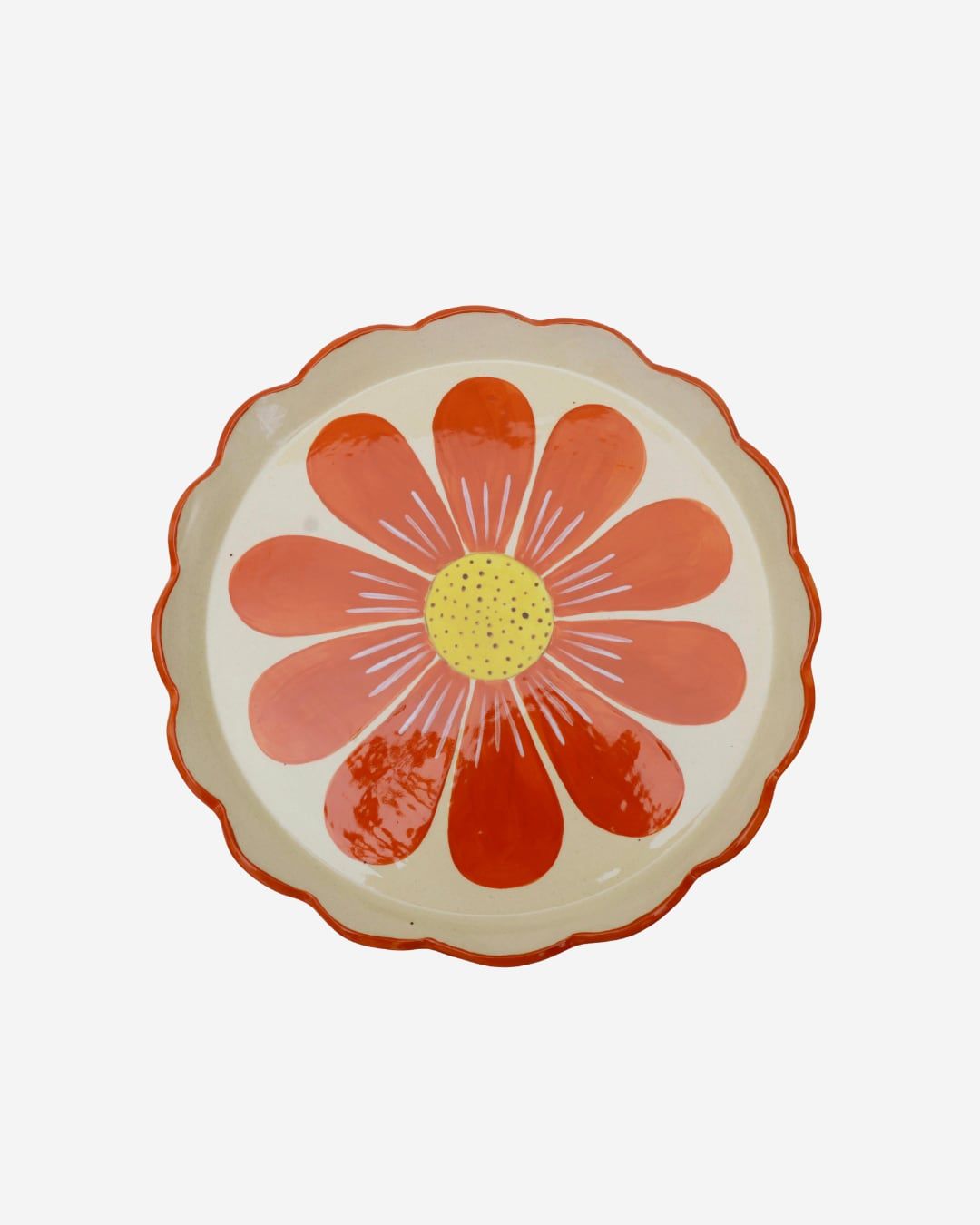 Prato de borda ondulada pintado com uma grande flor laranja de miolo amarelo.
