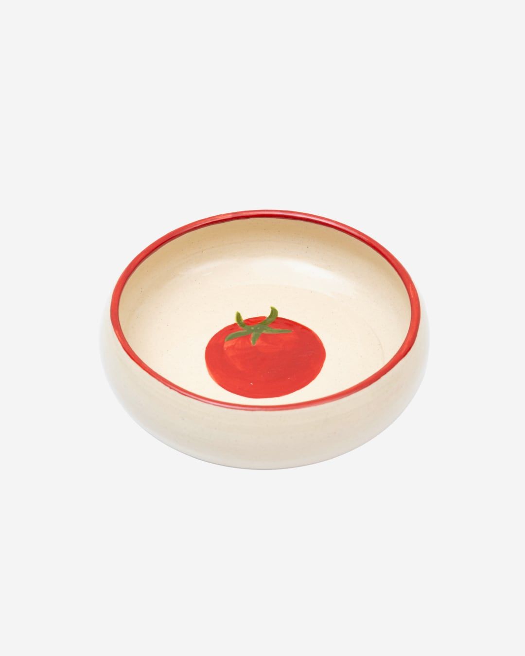 Tigela creme com borda vermelha e um tomate pintado no fundo.